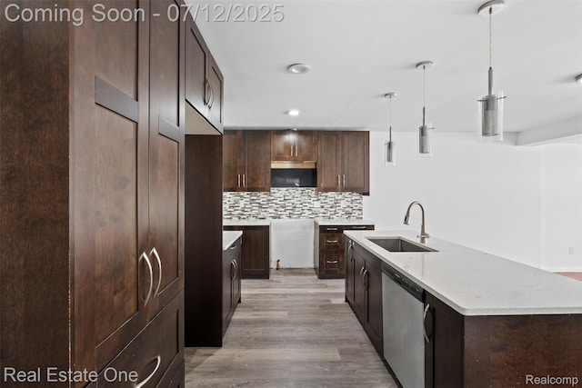 15679 Gulley St, Taylor, MI 48180 - kitchen with stainless steel dishwasher, backsplash, light wood-style flooring, a center island with sink, and dark brown cabinets