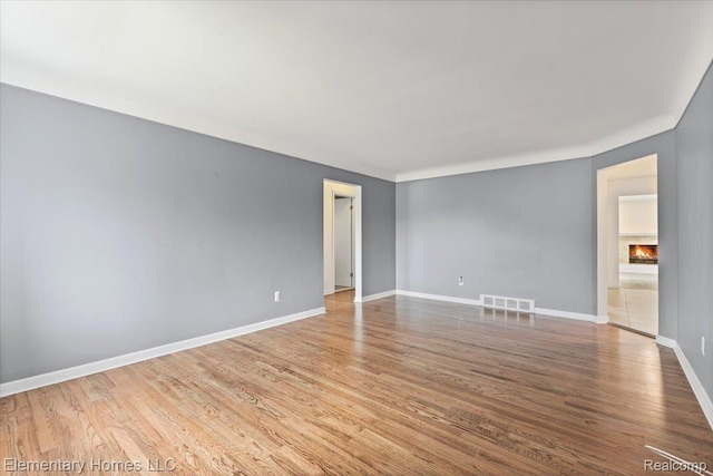 21142 Michael Ct, Saint Clair Shores, MI 48081 - unfurnished room featuring wood finished floors and a lit fireplace