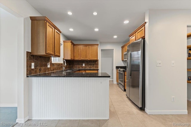21142 Michael Ct, Saint Clair Shores, MI 48081 - kitchen featuring stainless steel appliances, a peninsula, backsplash, dark stone countertops, and brown cabinetry