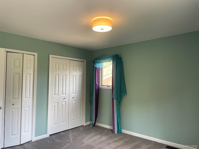 29494 Sylvan Ln Unit 6, Farmington Hills, MI 48334 - unfurnished bedroom featuring dark colored carpet and multiple closets