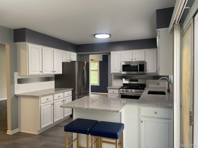 29494 Sylvan Ln Unit 6, Farmington Hills, MI 48334 - kitchen featuring a peninsula, appliances with stainless steel finishes, backsplash, white cabinets, and dark wood-style flooring