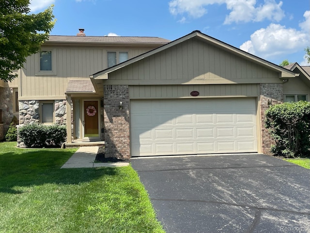 29494 Sylvan Ln Unit 6, Farmington Hills, MI 48334 - view of front facade with a garage, driveway, a front yard, a chimney, and brick siding