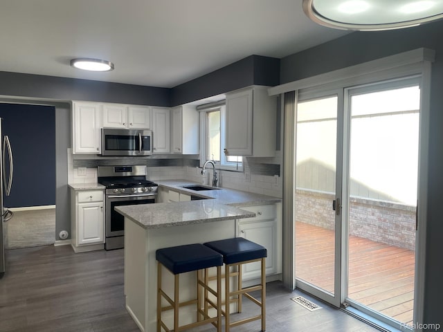 29494 Sylvan Ln Unit 6, Farmington Hills, MI 48334 - kitchen featuring stainless steel appliances, white cabinetry, tasteful backsplash, and dark wood-type flooring