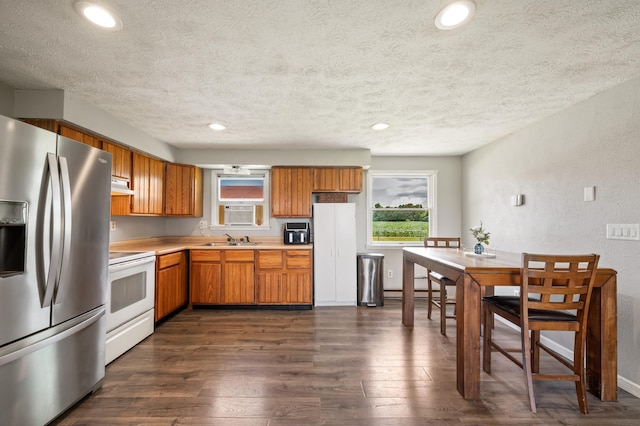 28644 Elm St, Dowagiac, MI 49047 - kitchen with stainless steel fridge, white range with electric cooktop, a textured ceiling, under cabinet range hood, and brown cabinets
