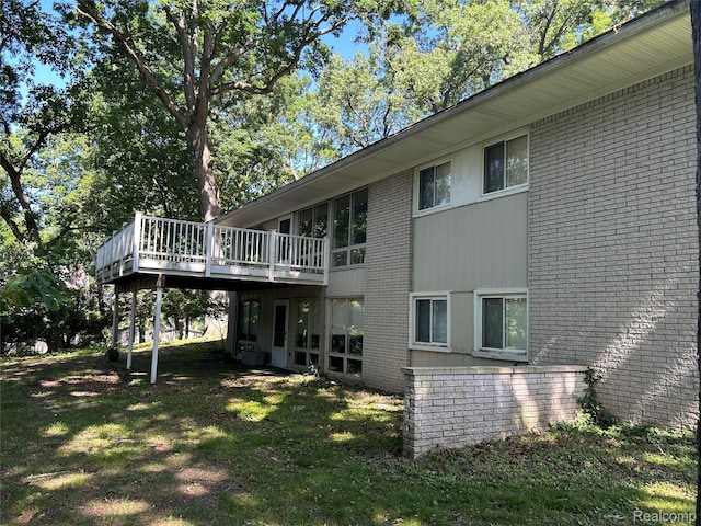 4230 Wendell Rd, West Bloomfield, MI 48323 - back of property with brick siding, a deck, and a lawn