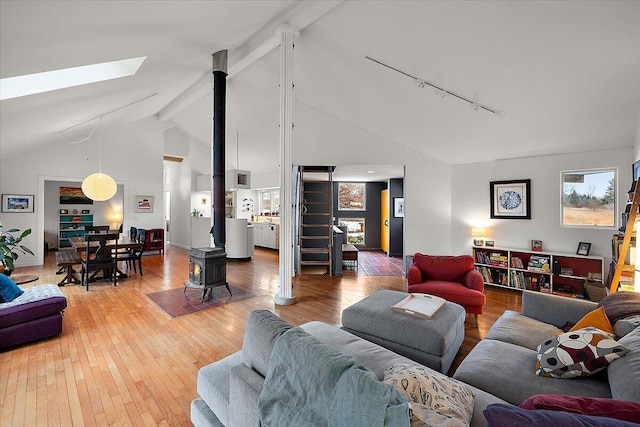 7227 Wheeler Rd, Whitmore Lake, MI 48189 - living room featuring track lighting, light wood-style floors, high vaulted ceiling, a skylight, and beamed ceiling