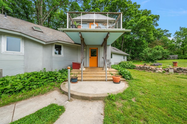 7227 Wheeler Rd, Whitmore Lake, MI 48189 - view of front of house with a front yard, stucco siding, a shingled roof, and a balcony