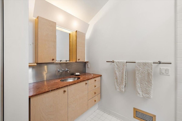 7227 Wheeler Rd, Whitmore Lake, MI 48189 - bathroom featuring vanity, tile patterned flooring, tasteful backsplash, and lofted ceiling