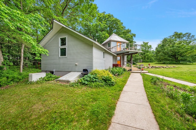 7227 Wheeler Rd, Whitmore Lake, MI 48189 - view of property exterior with a balcony and a lawn