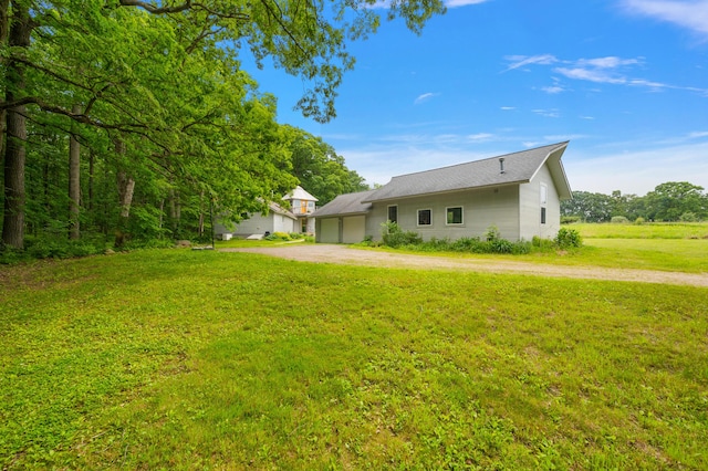 7227 Wheeler Rd, Whitmore Lake, MI 48189 - view of side of property featuring driveway, a yard, and an attached garage