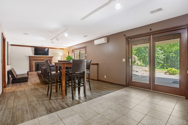 8608 Woodruff Dr SW, Byron Center, MI 49315 - tiled dining area featuring track lighting, a wall mounted air conditioner, and a fireplace