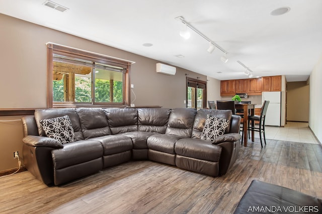 8608 Woodruff Dr SW, Byron Center, MI 49315 - living area featuring a wall unit AC, light wood finished floors, and track lighting