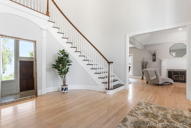 8608 Woodruff Dr SW, Byron Center, MI 49315 - foyer entrance with a high ceiling, wood finished floors, stairway, and a glass covered fireplace