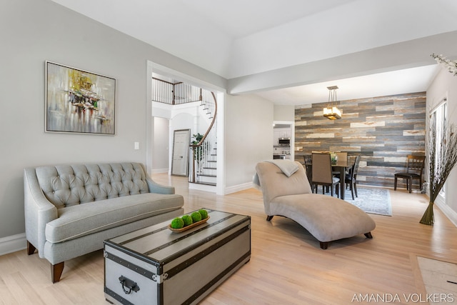 8608 Woodruff Dr SW, Byron Center, MI 49315 - living room with an accent wall, stairs, light wood-type flooring, and arched walkways