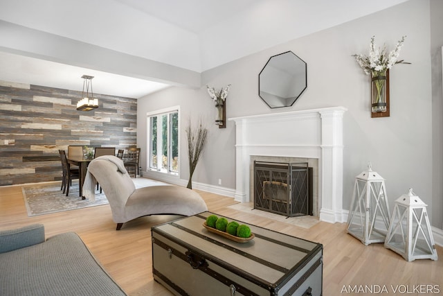 8608 Woodruff Dr SW, Byron Center, MI 49315 - living area featuring an accent wall, wood finished floors, a tile fireplace, and wood walls