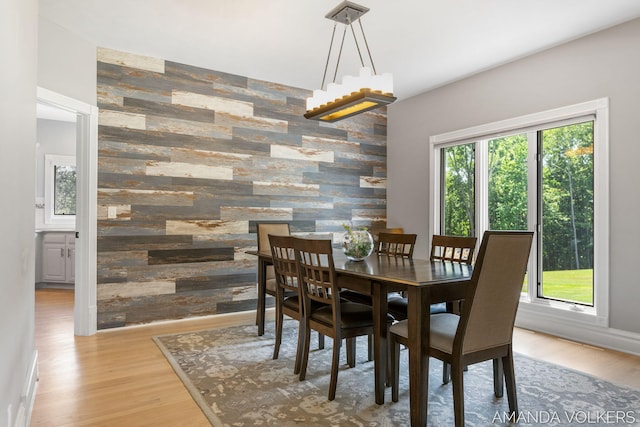 8608 Woodruff Dr SW, Byron Center, MI 49315 - dining area featuring an accent wall, wood walls, and wood finished floors