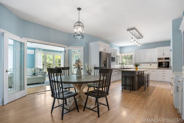 8608 Woodruff Dr SW, Byron Center, MI 49315 - dining room with healthy amount of natural light, a chandelier, and light wood-type flooring