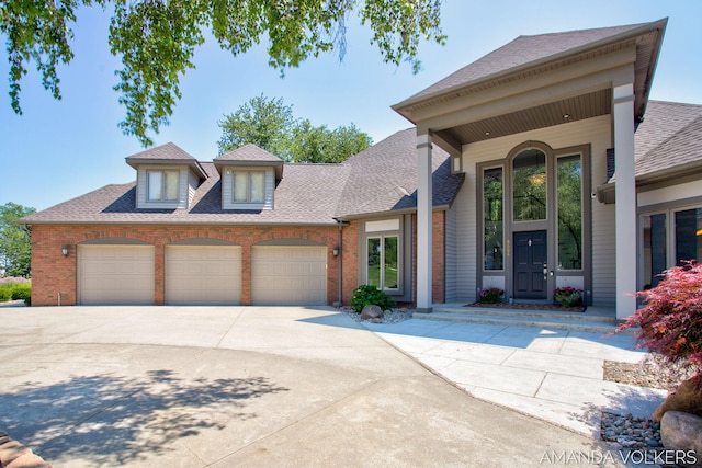 8608 Woodruff Dr SW, Byron Center, MI 49315 - view of front of property featuring brick siding, an attached garage, a shingled roof, and concrete driveway