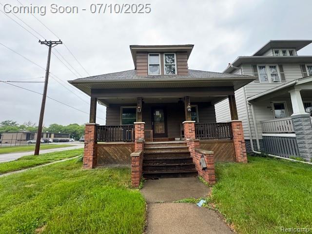566 Elm St, Wyandotte, MI 48192 - view of front of property with covered porch and a front lawn