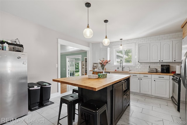 1406 Country View Ln, Flint, MI 48532 - kitchen with wood counters, light marble finish flooring, appliances with stainless steel finishes, and white cabinetry