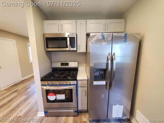 4638 Gertrude St, Dearborn Heights, MI 48125 - kitchen with stainless steel appliances, light wood finished floors, white cabinets, and light countertops