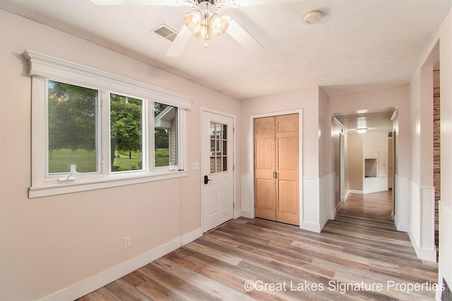 6047 Belding Rd, Belding, MI 48809 - foyer with light wood finished floors, a wainscoted wall, and ceiling fan