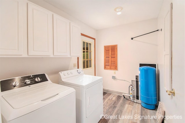 6047 Belding Rd, Belding, MI 48809 - washroom with cabinet space, independent washer and dryer, and light wood finished floors