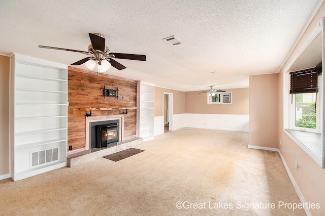 6047 Belding Rd, Belding, MI 48809 - unfurnished living room featuring a ceiling fan, carpet floors, a tile fireplace, a textured ceiling, and built in features