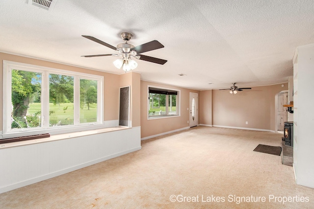 6047 Belding Rd, Belding, MI 48809 - unfurnished living room featuring a ceiling fan, light colored carpet, a textured ceiling, and a lit fireplace