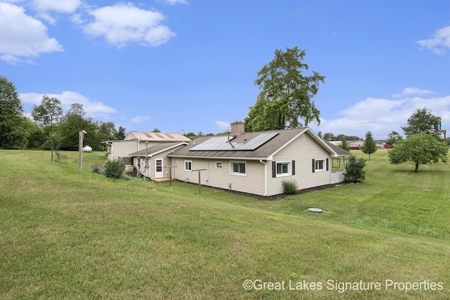 6047 Belding Rd, Belding, MI 48809 - back of property featuring solar panels, a lawn, and a chimney
