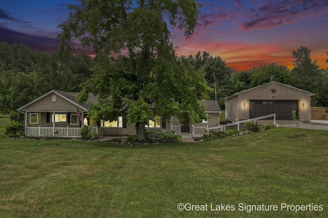 6047 Belding Rd, Belding, MI 48809 - view of front of property featuring covered porch, an outbuilding, a garage, and a lawn