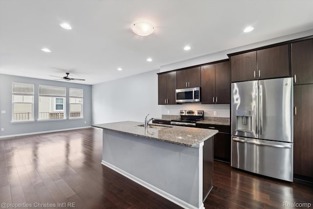 1051 N Sherman Dr Unit B19, Royal Oak, MI 48067 - kitchen with stainless steel appliances, dark wood-style flooring, ceiling fan, dark brown cabinets, and light stone counters
