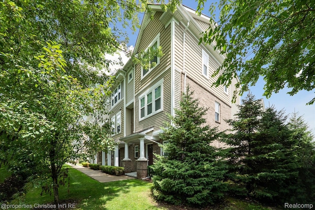 1051 N Sherman Dr Unit B19, Royal Oak, MI 48067 - view of property exterior featuring brick siding and a lawn