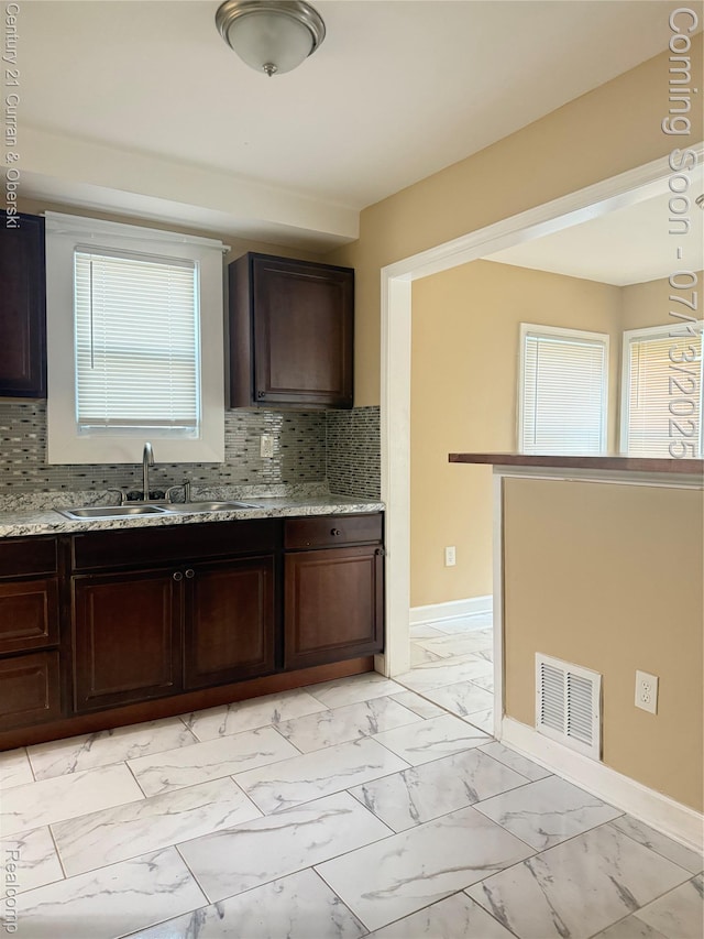 19928 Avon Ave, Detroit, MI 48219 - kitchen featuring plenty of natural light, light marble finish floors, and backsplash