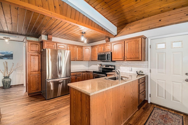 6706 E Carrigan Dr, Newaygo, MI 49337 - kitchen with appliances with stainless steel finishes, a peninsula, backsplash, light wood-type flooring, and a wooden ceiling with exposed beams