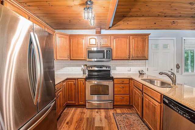 6706 E Carrigan Dr, Newaygo, MI 49337 - kitchen with stainless steel appliances, wood ceiling, light wood-style flooring, light stone counters, and brown cabinets