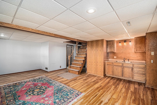 6706 E Carrigan Dr, Newaygo, MI 49337 - finished below grade area with light wood-style floors, a paneled ceiling, stairway, and wooden walls