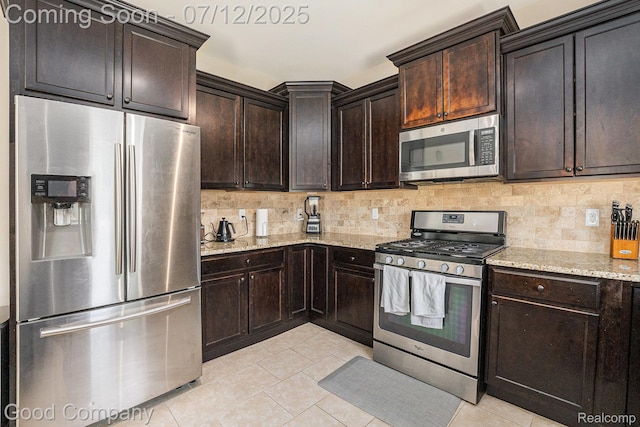 2920 Hartline Dr, Rochester Hills, MI 48309 - kitchen featuring appliances with stainless steel finishes, light tile patterned flooring, light stone counters, and decorative backsplash