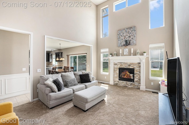 2920 Hartline Dr, Rochester Hills, MI 48309 - living room with a high ceiling, carpet, a stone fireplace, and wainscoting