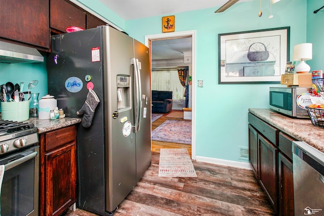 8124 Bailey St, Taylor, MI 48101 - kitchen with stainless steel appliances, wall chimney exhaust hood, wood finished floors, and ceiling fan