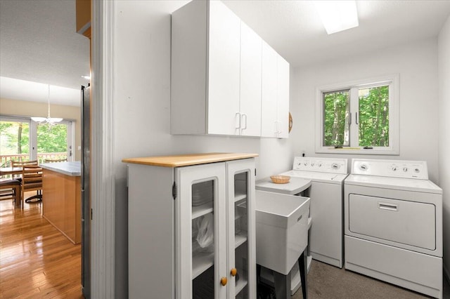 9650 Killdeer Ct, Canadian Lakes, MI 49346 - washroom featuring cabinet space, washer and dryer, and light wood-type flooring