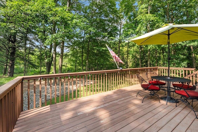 9650 Killdeer Ct, Canadian Lakes, MI 49346 - wooden terrace featuring outdoor dining space and view of scattered trees
