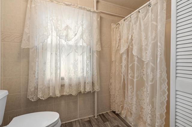 1310 Washington Ave, Kalamazoo, MI 49001 - bathroom featuring wood finished floors, a shower with curtain, and tile walls