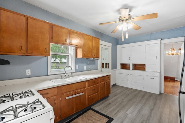 1310 Washington Ave, Kalamazoo, MI 49001 - kitchen with light countertops, light wood-type flooring, a ceiling fan, and a chandelier