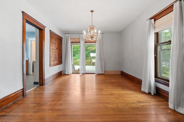 1310 Washington Ave, Kalamazoo, MI 49001 - spare room featuring a chandelier, healthy amount of natural light, and light wood-type flooring