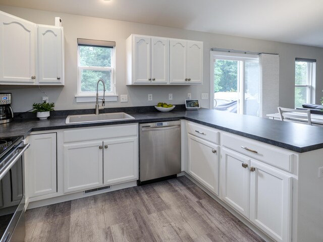 3740 Pristine Ave, Kalamazoo, MI 49048 - kitchen featuring stainless steel appliances, a peninsula, dark countertops, and plenty of natural light