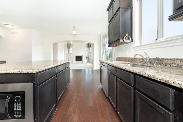 4215 Chandi Ct, Ypsilanti, MI 48197 - kitchen with arched walkways, dark wood-type flooring, dishwasher, light stone counters, and open floor plan