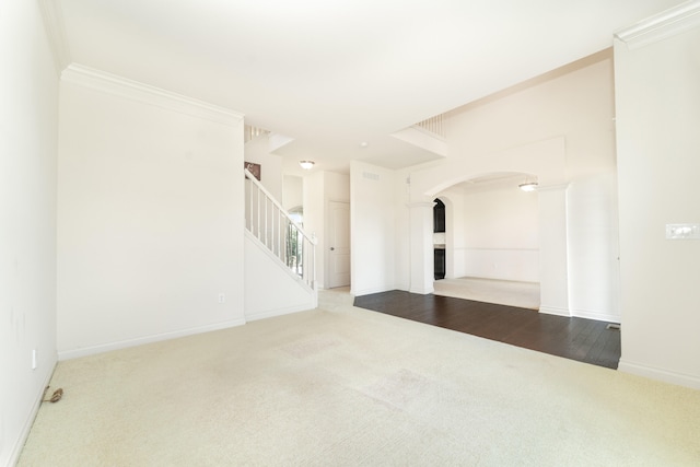 4215 Chandi Ct, Ypsilanti, MI 48197 - unfurnished living room with carpet floors, arched walkways, stairway, and crown molding