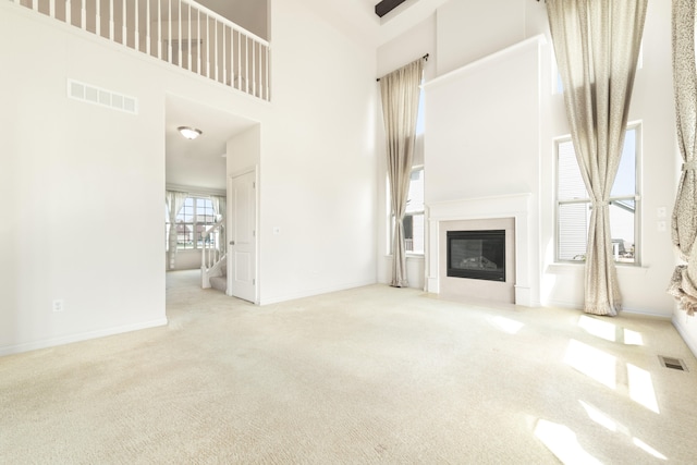 4215 Chandi Ct, Ypsilanti, MI 48197 - unfurnished living room with a towering ceiling, carpet, and a fireplace with flush hearth