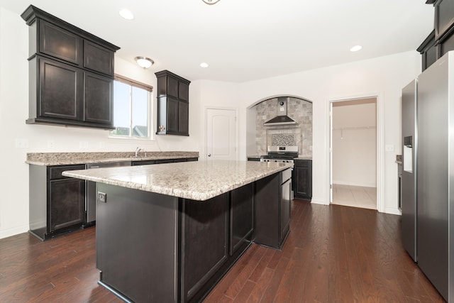 4215 Chandi Ct, Ypsilanti, MI 48197 - kitchen with stainless steel fridge, a kitchen island, dark wood finished floors, wall chimney exhaust hood, and recessed lighting